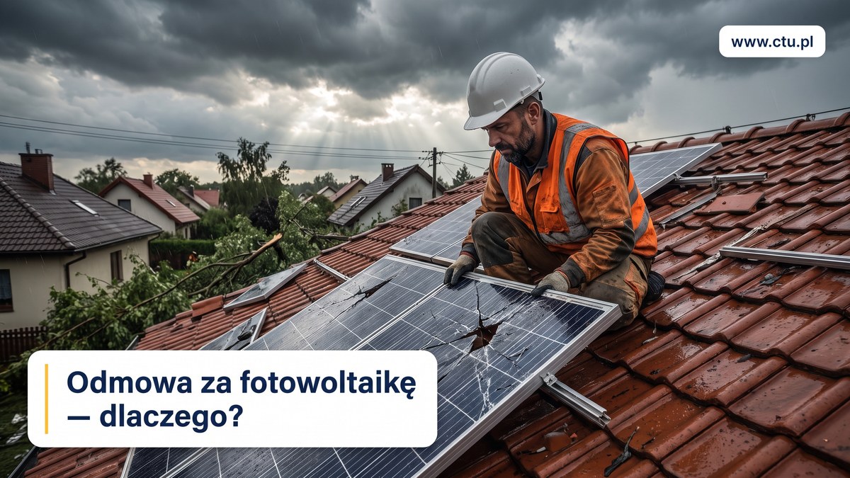 Instalator w kasku i kamizelce ogląda pęknięty panel fotowoltaiczny na dachu po burzy.