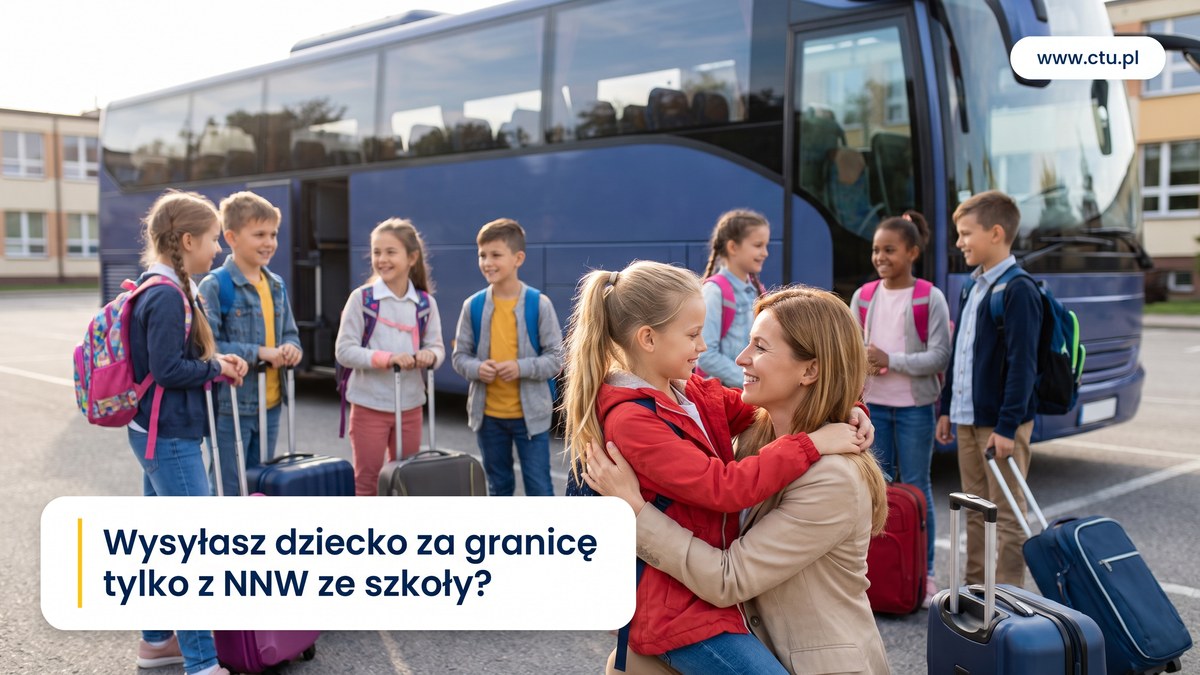 Dzieci z plecakami i walizkami stoją przy autokarze przed wyjazdem na wycieczkę, matka żegna córkę przytuleniem.